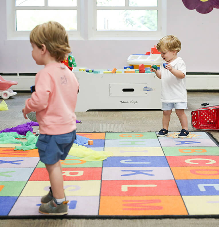 Toddlers on colorful play mat