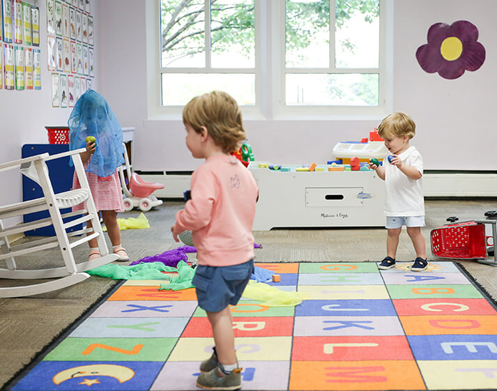 Toddler and baby playing on learning mat