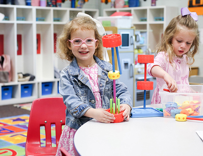 Toddler girls building at a table