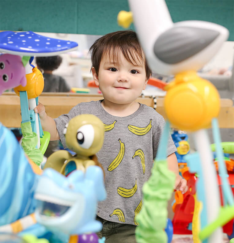 Toddler looking happy through some toys